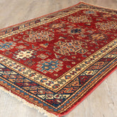 Decorative red rug with intricate patterns on a wooden floor