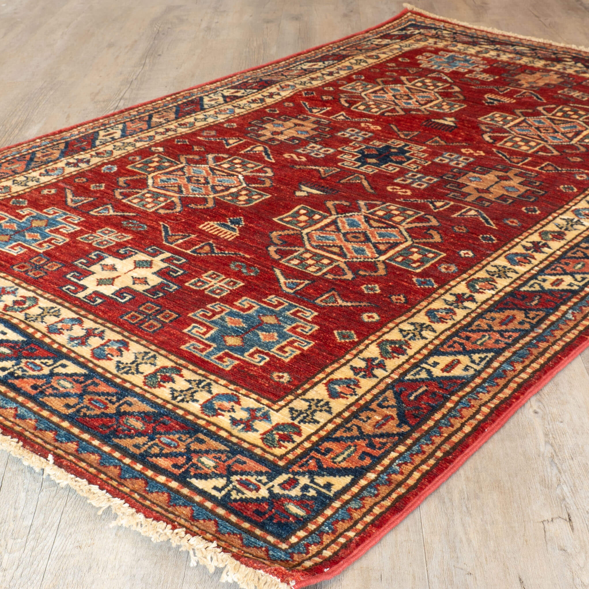 Decorative red rug with intricate patterns on a wooden floor